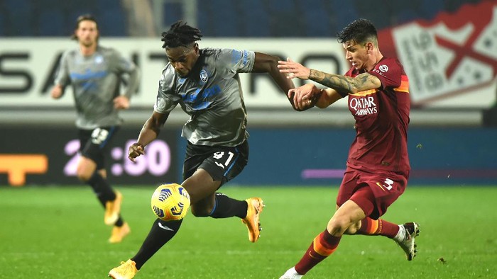 BERGAMO, ITALY - DECEMBER 20: Duvan Zapata of Atalanta B.C. battles for possession with Roger Ibanez of Roma  during the Serie A match between Atalanta BC and AS Roma at Gewiss Stadium on December 20, 2020 in Bergamo, Italy. Sporting stadiums around Italy remain under strict restrictions due to the Coronavirus Pandemic as Government social distancing laws prohibit fans inside venues resulting in games being played behind closed doors. (Photo by Pier Marco Tacca/Getty Images)