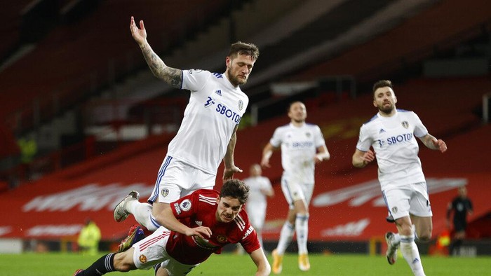 Manchester Uniteds Daniel James falls in front of Leeds Uniteds Liam Cooper during an English Premier League soccer match between Manchester United and Leeds United at the Old Trafford stadium in Manchester, England, Sunday Dec. 20, 2020. (Clive Brunskill/Pool via AP)