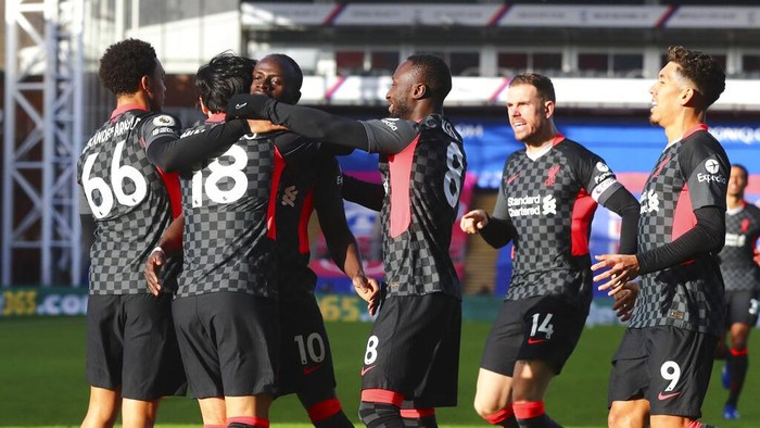 Liverpools Takumi Minamino celebrates with teammates after scoring his sides opening goal during the English Premier League soccer match between Crystal Palace and Liverpool at Selhurst Park stadium in London, Saturday, Dec. 19, 2020. (Clive Rose/Pool via AP)