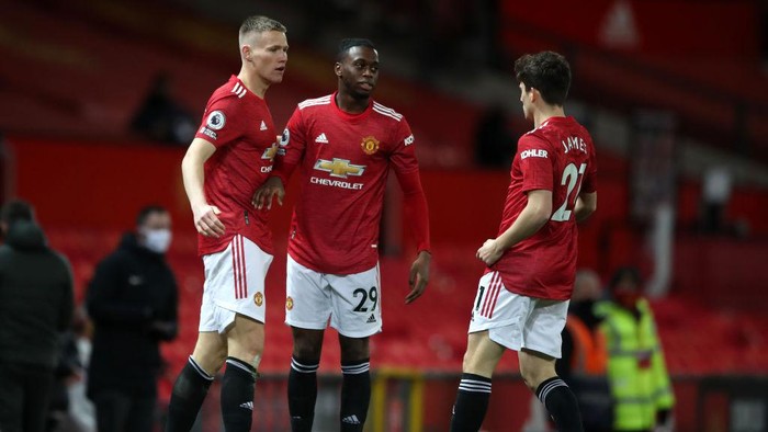 MANCHESTER, ENGLAND - DECEMBER 20: Scott McTominay of Manchester United celebrates with Aaron Wan-Bissaka and Daniel James after scoring their teams first goal during the Premier League match between Manchester United and Leeds United at Old Trafford on December 20, 2020 in Manchester, England. The match will be played without fans, behind closed doors as a Covid-19 precaution. (Photo by Nick Potts - Pool/Getty Images)