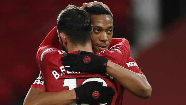 Manchester United's Bruno Fernandes, front, celebrates his side's sixth goal from a penalty kick with Anthony Martial during an English Premier League soccer match between Manchester United and Leeds United at the Old Trafford stadium in Manchester, England, Sunday Dec. 20, 2020. (Clive Brunskill/Pool via AP)