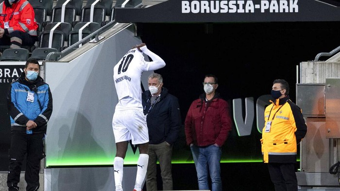 Moenchengladbachs Marcus Thuram leaves the pitch after getting a red card during their German Bundesliga soccer match between Borussia Moenchengladbach and 1899 Hoffenheim at Borussia-Park in Moenchengladbach, Germany, Saturday, Dec. 19, 2020. (Marius Becker/dpa via AP)