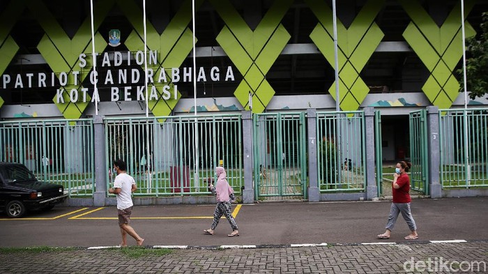 Petugas medis menggunakan Alat Pelindung Diri (APD) memeriksa kondisi pasien COVID-19 yang berstatus OTG (Orang Tanpa Gejala) saat kegiatan berjemur dan olahraga di Stadion Patriot Candrabhaga, Bekasi, Jawa Barat, Senin  (21/12/2020). Kegiatan pemeriksaan kesehatan, berjemur dan berolahraga tersebut rutin dilakukan setiap pagi hari untuk meningkatkan daya tahan tubuh pasien yang menjalani isolasi.