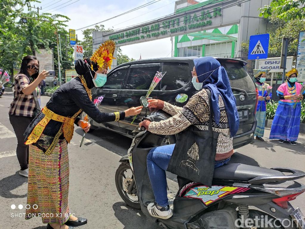 Jelang Hari Ibu, Nakes di Sidoarjo Pakai Baju Adat Bagikan Bunga-Masker