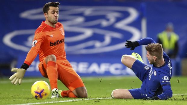 Chelsea's Timo Werner, right, slides towards West Ham's goalkeeper Lukasz Fabianski during the English Premier League soccer match between Chelsea and West Ham at Stamford Bridge, London, Monday, Dec. 21, 2020. (AP Photo/Clive Rose,Pool)