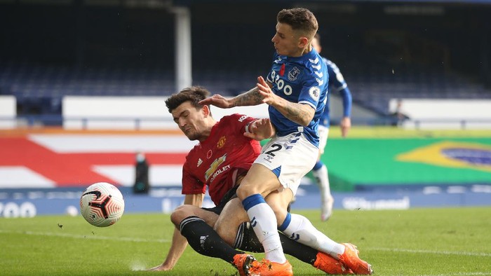 LIVERPOOL, ENGLAND - NOVEMBER 07: Harry Maguire of Manchester United is challenged by Lucas Digne of Everton during the Premier League match between Everton and Manchester United at Goodison Park on November 07, 2020 in Liverpool, England. Sporting stadiums around the UK remain under strict restrictions due to the Coronavirus Pandemic as Government social distancing laws prohibit fans inside venues resulting in games being played behind closed doors. (Photo by Carl Recine - Pool/Getty Images)