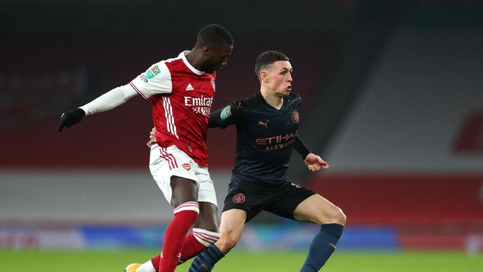 LONDON, ENGLAND - DECEMBER 22: Phil Foden of Manchester City is challenged by Nicolas Pepe of Arsenal during the Carabao Cup Quarter Final match between Arsenal and Manchester City at Emirates Stadium on December 22, 2020 in London, England. The match will be played without fans, behind closed doors as a Covid-19 precaution. (Photo by Catherine Ivill/Getty Images)