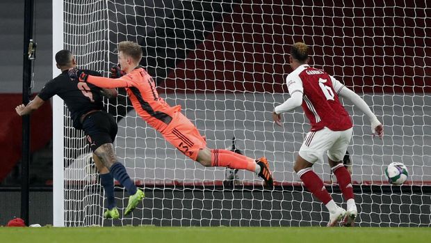 Manchester City's Gabriel Jesus, left, heads the ball past Arsenal's goalkeeper Runar Alex Runarsson to score his team's first goal during the English League Cup quarterfinal soccer match between Arsenal and Manchester City at Emirates Stadium, London, Tuesday, Dec. 22, 2020. (AP Photo/Frank Augstein)
