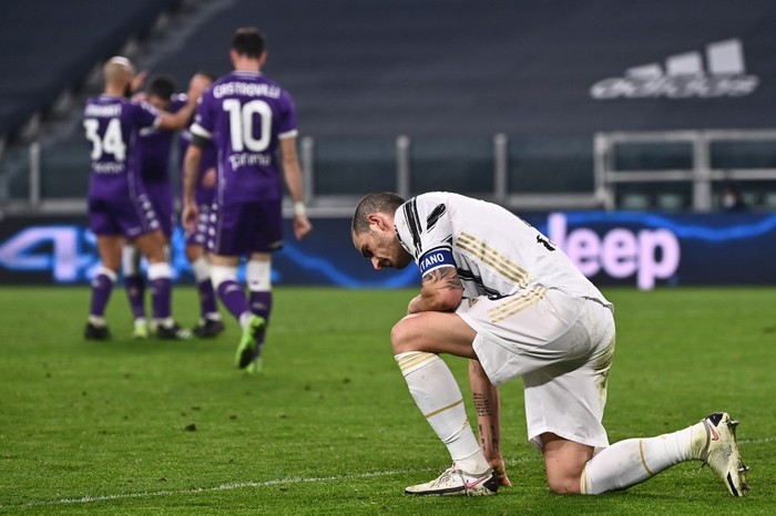 Juventus Italian defender Leonardo Bonucci (R) reacts as Fiorentinas players celebrate (Rear L) after Juventus scored an own goal during the Italian Serie A football match Juventus vs Fiorentina on December 22, 2020 at the Juventus stadium in Turin. (Photo by Marco BERTORELLO / AFP)