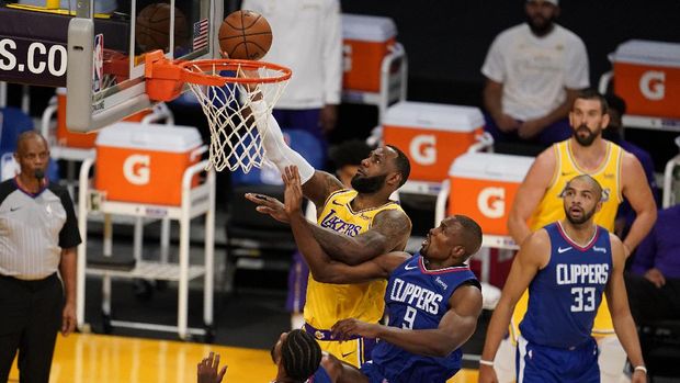 Los Angeles Lakers forward LeBron James, top, drives to the basket over Los Angeles Clippers center Serge Ibaka (9) during the first half of an NBA basketball game Tuesday, Dec. 22, 2020, in Los Angeles. (AP Photo/Marcio Jose Sanchez)