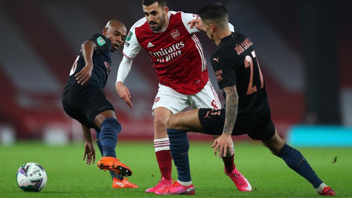 LONDON, ENGLAND - DECEMBER 22: Dani Ceballos of Arsenal is challenged by Joao Cancelo and Fernandinho of Manchester City during the Carabao Cup Quarter Final match between Arsenal and Manchester City at Emirates Stadium on December 22, 2020 in London, England. The match will be played without fans, behind closed doors as a Covid-19 precaution. (Photo by Catherine Ivill/Getty Images)