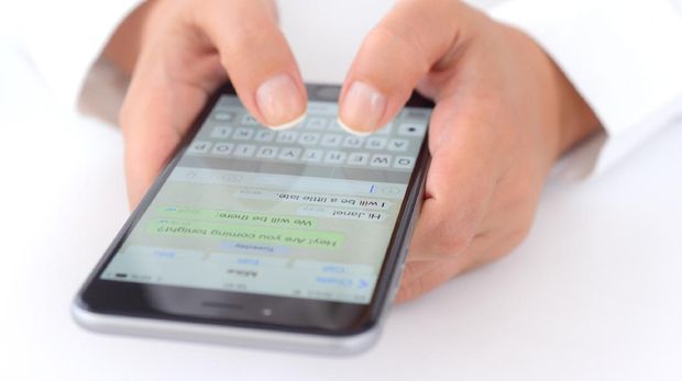 İstanbul, Turkey - July 14, 2015: Hands holding a iPhone 6 Plus displaying WhatsApp messaging application. iPhone is a touchscreen smart phone produced by Apple Inc.