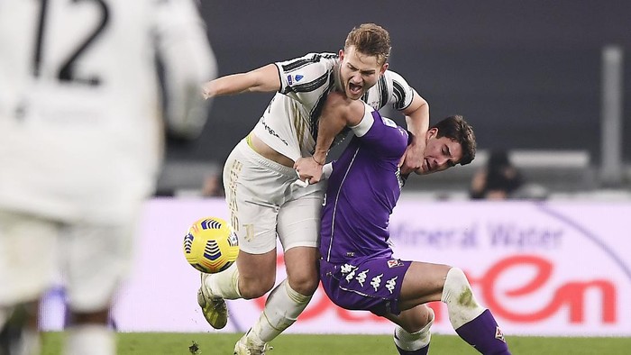 Juventus Matthijs de Ligt, left, and Fiorentinas Dusan Vlahovic compete for the ball during the Serie A soccer match between Juventus and Fiorentina, at the Allianz Stadium in Turin, Italy, Tuesday, Dec. 22, 2020. (Fabio Ferrari/LaPresse via AP)