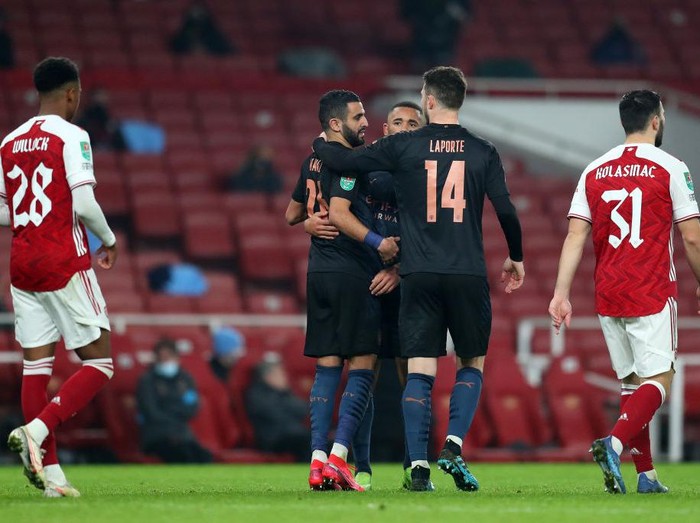 LONDON, ENGLAND - DECEMBER 22: Riyad Mahrez of Manchester City celebrates with Gabriel Jesus and Aymeric Laporte after scoring their sides second goal during the Carabao Cup Quarter Final match between Arsenal and Manchester City at Emirates Stadium on December 22, 2020 in London, England. The match will be played without fans, behind closed doors as a Covid-19 precaution. (Photo by Catherine Ivill/Getty Images)