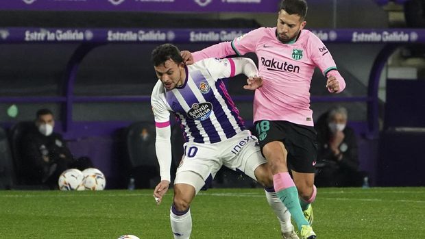 Valladolid's Oscar Plano, left, challenges for the ball with Barcelona's Jordi Alba during a Spanish La Liga soccer match between Valladolid and Barcelona at the Jose Zorrilla stadium in Valladolid, Spain,Tuesday Dec. 22, 2020. (Cesar Manso/Pool via AP)
