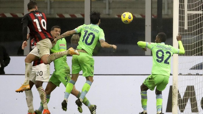 AC Milans Theo Hernandez, left, scores the third goal for Milan against Lazio during a Serie A soccer match between AC Milan and Lazio, at the San Siro stadium in Milan, Italy, Wednesday, Dec. 23, 2020. (AP Photo/Luca Bruno)