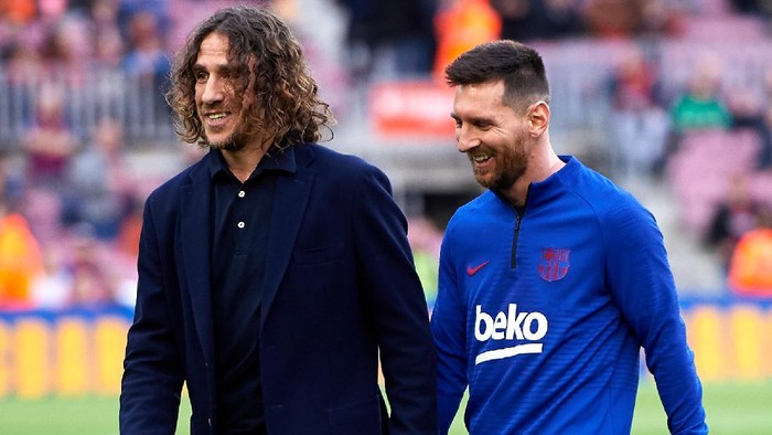 BARCELONA, SPAIN - DECEMBER 21: Lionel Messi of FC Barcelona walks with former teammate Carles Puyol before the La Liga match between FC Barcelona and Deportivo Alaves at Camp Nou on December 21, 2019 in Barcelona, Spain. (Photo by Alex Caparros/Getty Images)