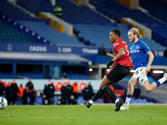LIVERPOOL, ENGLAND - DECEMBER 23: Anthony Martial of Manchester United scores their teams second goal under pressure from Tom Davies of Everton during the Carabao Cup Quarter Final match between Everton and Manchester United at Goodison Park on December 23, 2020 in Liverpool, England.  A limited number of fans (2000) are welcomed back to stadiums to watch elite football across England. This was following easing of restrictions on spectators in tiers one and two areas only. (Photo by Clive Brunskill/Getty Images)