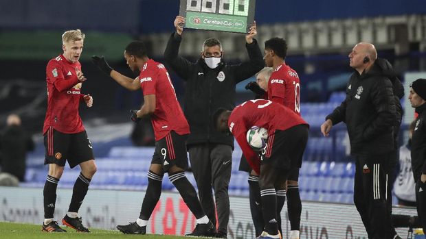 Manchester United's Donny van der Beek, left, gestures to teammate Anthony Martial as he is replaced during the English League Cup quarterfinal soccer match between Everton and Manchester United at Goodison Park, Liverpool, England, Wednesday, Dec. 23, 2020. (AP Photo/Nick Potts,Pool)