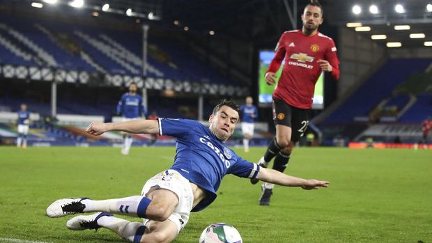 Everton's Seamus Coleman slides to keep the ball in play during the English League Cup quarterfinal soccer match between Everton and Manchester United at Goodison Park, Liverpool, England, Wednesday, Dec. 23, 2020. (AP Photo/Nick Potts,Pool)