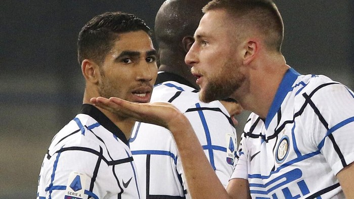 Inter Milan’s Milan Skriniar, right, celebrates after scoring his sides second goal  during the Serie A soccer match between Verona and Inter Milan in Verona, Italy Wednesday, Dec. 23, 2020.  (Paola Garbuio/LaPresse via AP)