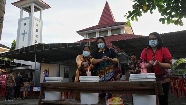 Umat Katolik mencuci tangan sebelum mengikuti misa Natal 2020 di Gereja St. Thomas, Seyegan, Sleman, D.I Yogyakarta, Kamis (24/12/2020). Sejumlah gereja di Yogyakarta merayakan Natal secara tatap muka dengan menerapkan protokol kesehatan COVID-19. ANTARA FOTO/Andreas Fitri Atmoko/aww.