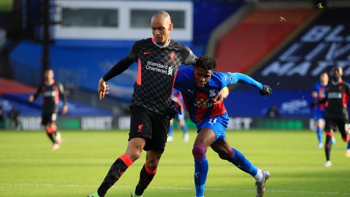 LONDON, ENGLAND - DECEMBER 19:  Fabinho of Liverpool is challenged by Wilfried Zaha of Crystal Palace during the Premier League match between Crystal Palace and Liverpool at Selhurst Park on December 19, 2020 in London, England. The match will be played without fans, behind closed doors as a Covid-19 precaution. (Photo by Adam Davy - Pool/Getty Images)