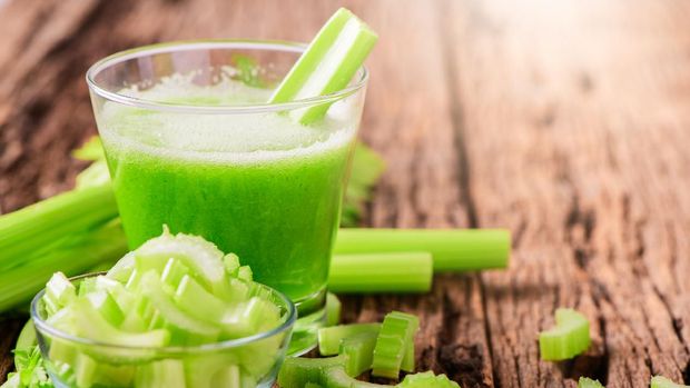 Fresh green celery juice in glass on wooden brown background, Healthy food, detox and healthy concept