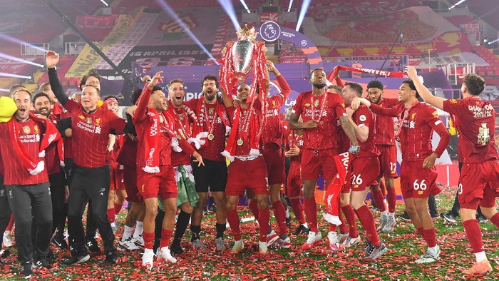 LIVERPOOL, ENGLAND - JULY 22: Fabinho of Liverpool leads the celebrations holding the trophy aloft as they celebrate winning the Title during the presentation ceremony of  the Premier League match between Liverpool FC and Chelsea FC at Anfield on July 22, 2020 in Liverpool, England. Football Stadiums around Europe remain empty due to the Coronavirus Pandemic as Government social distancing laws prohibit fans inside venues resulting in games being played behind closed doors. (Photo by Laurence Griffiths/Getty Images)