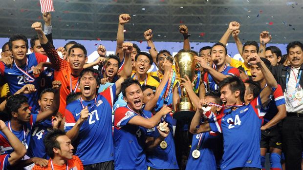 Malaysia's players and officials hold the AFF Suzuki 2010 trophy after defeating Indonesia during the final of in the AFF Suzuki Cup 2010 in Jakarta on December 29, 2010.  AFP PHOTO / ADEK BERRY (Photo by ADEK BERRY / AFP)