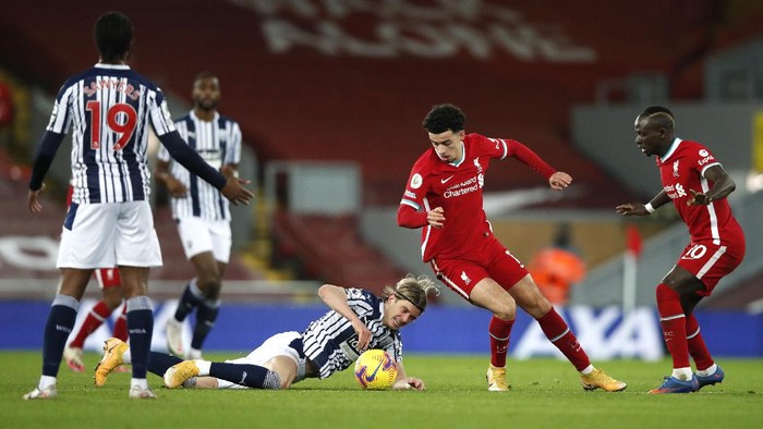 LIVERPOOL, ENGLAND - DECEMBER 27: Conor Gallagher of West Bromwich Albion is tackled by Curtis Jones of Liverpool during the Premier League match between Liverpool and West Bromwich Albion at Anfield on December 27, 2020 in Liverpool, England. A limited number of fans (2000) are welcomed back to stadiums to watch elite football across England. This was following easing of restrictions on spectators in tiers one and two areas only. (Photo by Clive Brunskill/Getty Images)