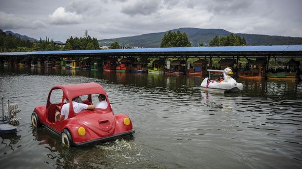 Wisatawan menaiki perahu di tempat Wisata Floating Market, Lembang, Kabupaten Bandung Barat, Jawa Barat, Sabtu (26/12/2020). Memasuki libur panjang Natal dan Tahun Baru 2021, wisata Floating market mulai dipadati wisatawan dengan tetap menerapkan protokol kesehatan di tengah pandemi COVID-19. ANTARA FOTO/Raisan Al Farisi/pras.