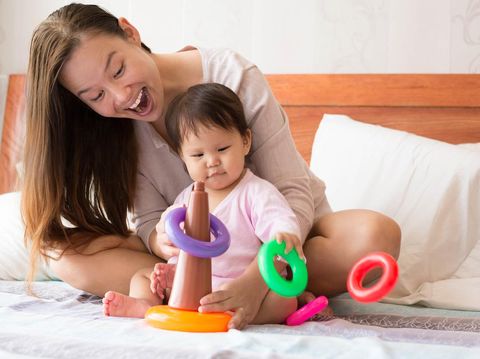 Young parents and toddler daughter playing in sitting room