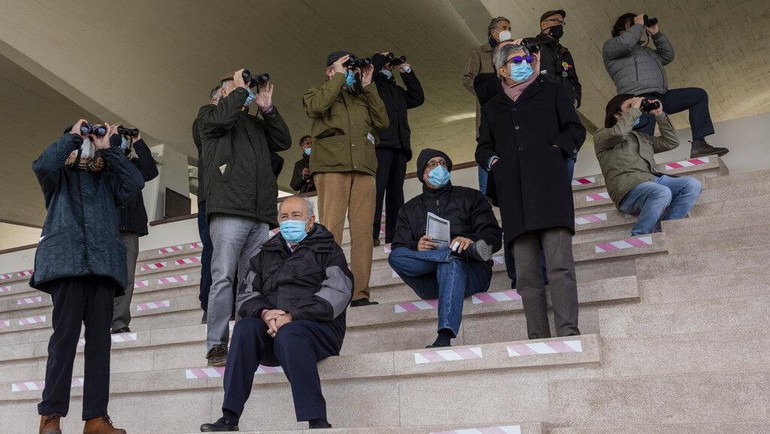 Pita perekat menandai ruang di tribun untuk memastikan pengurangan jumlah penonton yang diperbolehkan dalam menjaga jarak yang tepat dari satu sama lain.  