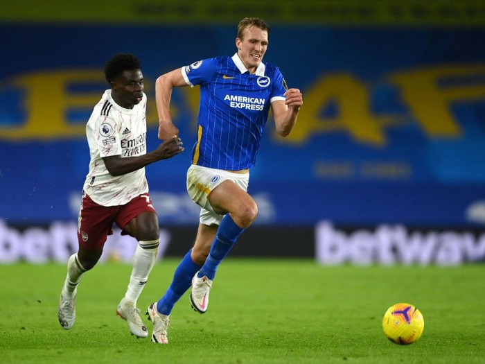 BRIGHTON, ENGLAND - DECEMBER 29: Bukayo Saka of Arsenal goes past Dan Burn of Brighton & Hove Albion during the Premier League match between Brighton & Hove Albion and Arsenal at American Express Community Stadium on December 29, 2020 in Brighton, England. The match will be played without fans, behind closed doors as a Covid-19 precaution. (Photo by Mike Hewitt/Getty Images)