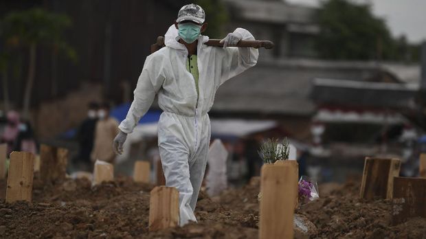 Petugas yang mengenakan APD bersiap memakamkan jenazah dengan protokol COVID-19 di TPU Tegal Alur, Jakarta, Selasa (29/12/2020). Pemprov DKI Jakarta menyiapkan lahan pemakaman di Rorotan sebagai antisipasi penuhnya TPU khusus COVID-19 di Pondok Ranggon dan Tegal Alur karena masih tingginya jumlah kematian akibat COVID-19. ANTARA FOTO/Wahyu Putro A/aww.