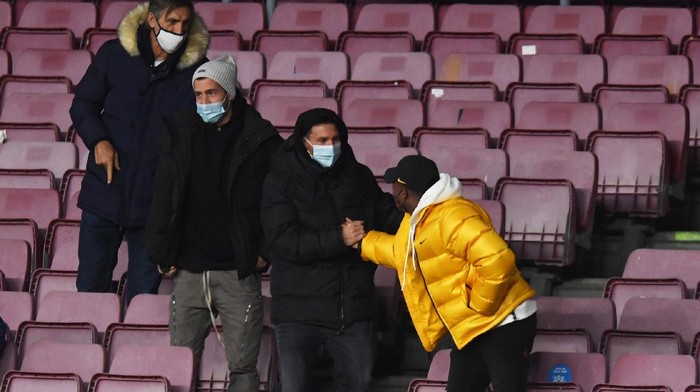 BARCELONA, SPAIN - DECEMBER 29: Lionel Messi of Barcelona is seen in the stands greeting Anssumane Ansu Fati during the La Liga Santander match between FC Barcelona and SD Eibar at Camp Nou on December 29, 2020 in Barcelona, Spain. Sporting stadiums around Spain remain under strict restrictions due to the Coronavirus Pandemic as Government social distancing laws prohibit fans inside venues resulting in games being played behind closed doors. (Photo by Alex Caparros/Getty Images)