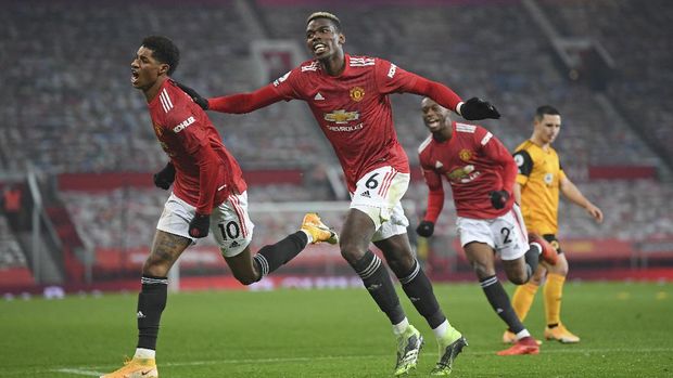 Manchester United's Marcus Rashford, left, celebrates with Paul Pogba after scoring the opening goal during the English Premier League soccer match between Manchester Utd and Wolverhampton Wanderers at Old Trafford stadium in Manchester, England, Tuesday,Dec. 29, 2020. (Michael Regan, Pool via AP)