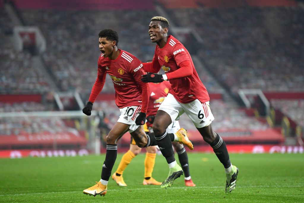 MANCHESTER, ENGLAND - DECEMBER 29: Marcus Rashford of Manchester United celebrates with teammate Paul Pogba after scoring his team's first goal during the Premier League match between Manchester United and Wolverhampton Wanderers at Old Trafford on December 29, 2020 in Manchester, England. The match will be played without fans, behind closed doors as a Covid-19 precaution. (Photo by Michael Regan/Getty Images)