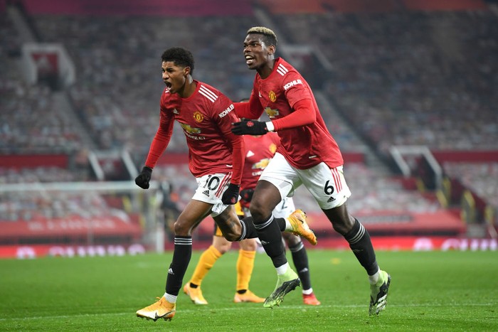 MANCHESTER, ENGLAND - DECEMBER 29: Marcus Rashford of Manchester United celebrates with teammate Paul Pogba after scoring his teams first goal during the Premier League match between Manchester United and Wolverhampton Wanderers at Old Trafford on December 29, 2020 in Manchester, England. The match will be played without fans, behind closed doors as a Covid-19 precaution. (Photo by Michael Regan/Getty Images)