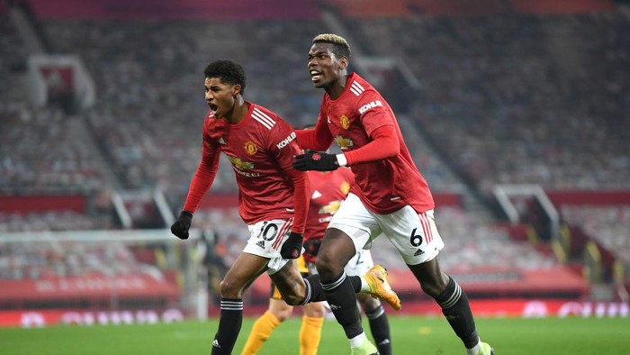 Marcus Rashford MANCHESTER, ENGLAND - DECEMBER 29: Marcus Rashford of Manchester United celebrates with teammate Paul Pogba after scoring his teams first goal during the Premier League match between Manchester United and Wolverhampton Wanderers at Old Trafford on December 29, 2020 in Manchester, England. The match will be played without fans, behind closed doors as a Covid-19 precaution. (Photo by Michael Regan/Getty Images)