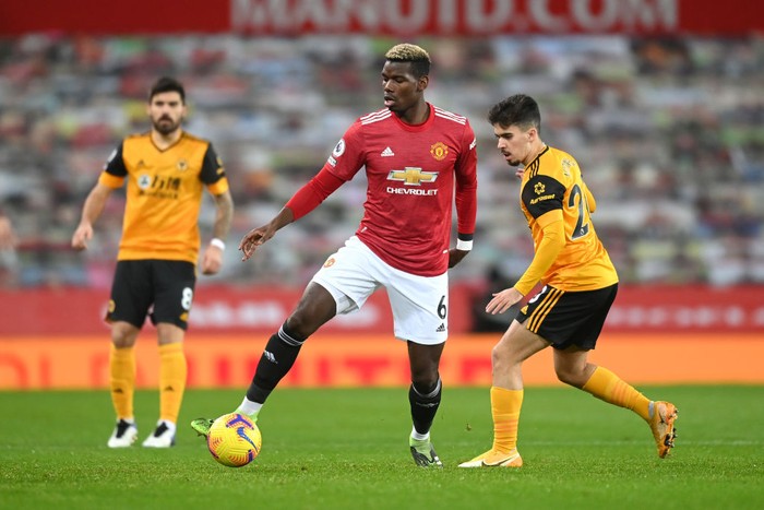 MANCHESTER, ENGLAND - DECEMBER 29: Paul Pogba of Manchester United controls the ball under pressure from Vitinha of Wolverhampton Wanderers during the Premier League match between Manchester United and Wolverhampton Wanderers at Old Trafford on December 29, 2020 in Manchester, England. The match will be played without fans, behind closed doors as a Covid-19 precaution. (Photo by Michael Regan/Getty Images)
