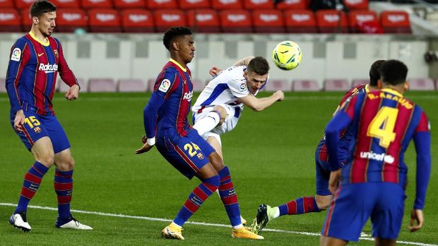 Barcelona's Junior Firpo, center left, blocks a shot by Eibar's Damian Kadzior, center right, during the Spanish La Liga soccer match between Barcelona and Eibar at the Camp Nou stadium in Barcelona in Barcelona, Spain, Tuesday, Dec. 29, 2020. (AP Photo/Joan Monfort)