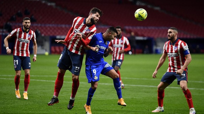 MADRID, SPAIN - DECEMBER 30: Felipe of Atletico de Madrid heads the ball clear under pressure from Angel Rodriguez of Getafe  during the La Liga Santander match between Atletico de Madrid and Getafe CF at Estadio Wanda Metropolitano on December 30, 2020 in Madrid, Spain. Sporting stadiums around Spain remain under strict restrictions due to the Coronavirus Pandemic as Government social distancing laws prohibit fans inside venues resulting in games being played behind closed doors. (Photo by Denis Doyle/Getty Images)