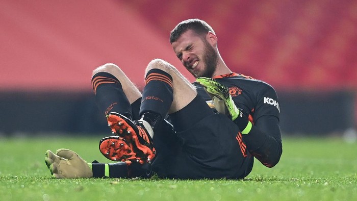MANCHESTER, ENGLAND - DECEMBER 29: David De Gea of Manchester United goes down injured during the Premier League match between Manchester United and Wolverhampton Wanderers at Old Trafford on December 29, 2020 in Manchester, England. The match will be played without fans, behind closed doors as a Covid-19 precaution. (Photo by Laurence Griffiths/Getty Images)