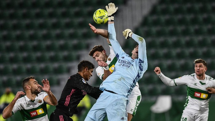 Real Madrids goalkeeper Thibaut Courtois and Elches Lucas Boye, center, jump for the ball during the Spanish La Liga soccer match between Real Madrid and Elche CF at the Manuel Martinez Valero stadium in Elche, Spain, Wednesday, Dec. 30, 2020. (AP Photo/Jose Breton)