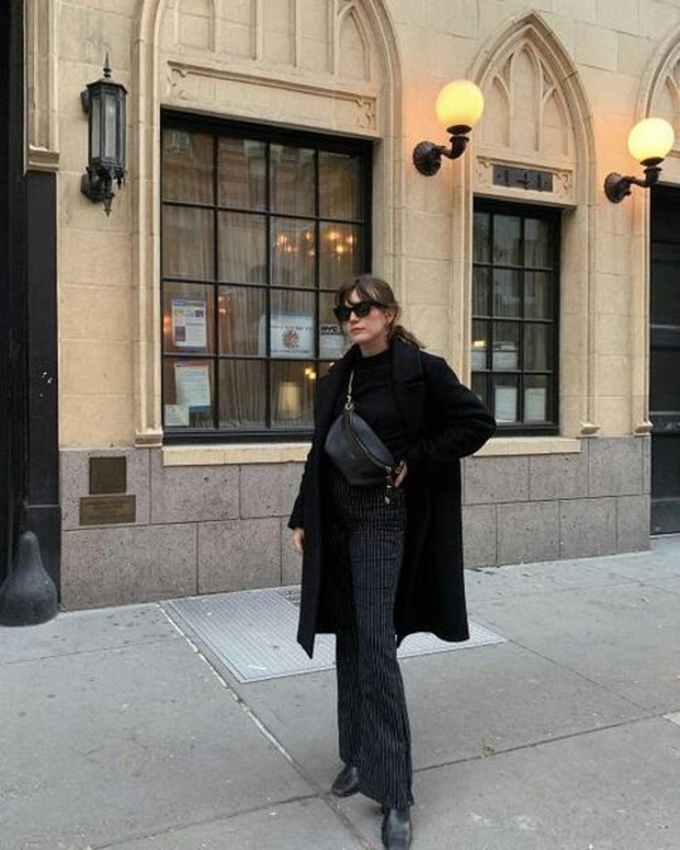 Flared pants bergaris vertikal adalah bagian bawah yang sempurna untuk dikenakan outfit serba hitam.