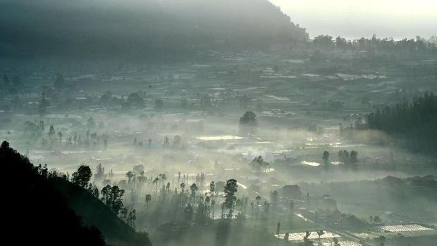 Suasana pemandangan pedesaan saat matahari terbit pertama tahun 2021 terlihat dari Desa Pinggan, Kintamani, Bangli, Bali, Jumat (1/1/2021). Kawasan wisata alam dengan pemandangan Gunung Agung, Gunung Batur dan Gunung Abang tersebut menjadi salah satu lokasi di Pulau Dewata yang dikunjungi wisatawan untuk menyaksikan matahari terbit pertama tahun 2021. ANTARA FOTO/Fikri Yusuf/PRAS.