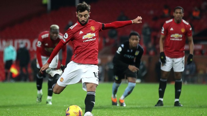 MANCHESTER, ENGLAND - JANUARY 01: Bruno Fernandes of Manchester United scores their teams second goal from the penalty spot during the Premier League match between Manchester United and Aston Villa at Old Trafford on January 01, 2021 in Manchester, England. The match will be played without fans, behind closed doors as a Covid-19 precaution. (Photo by Carl Recine - Pool/Getty Images)