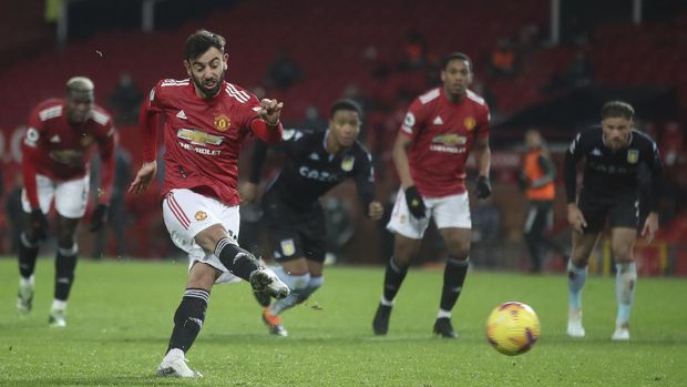 Manchester United's Bruno Fernandes shoots and scores his sides 2nd goal from the penalty spot during the English Premier League soccer match between Manchester United and Aston Villa at Old Trafford in Manchester, England, Friday, Jan. 1, 2021. (Carl Recine/ Pool via AP)